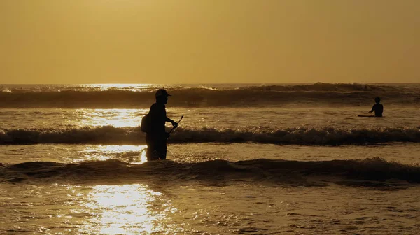 日落时带着桨冲浪的年轻人的轮廓 — 图库照片