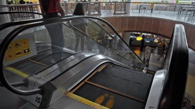 Kuta, Kabupaten Badung, Bali, Endonezya - 6 Kasım 2020: Toplumsal mesafeyi korumak için ayak izi işareti olan bir alışveriş merkezinde siyah merdiven yürüyen merdiven