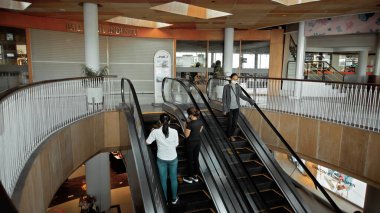 Kuta, Kabupaten Badung, Bali, Endonezya - 6 Kasım 2020: Toplumsal mesafeyi korumak için ayak izi işareti olan bir alışveriş merkezinde siyah merdiven yürüyen merdiven