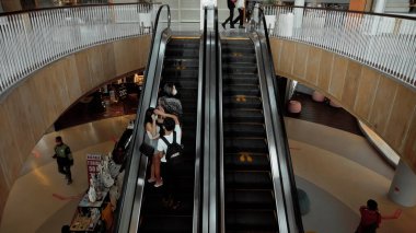 Kuta, Kabupaten Badung, Bali, Endonezya - 6 Kasım 2020: Toplumsal mesafeyi korumak için ayak izi işareti olan bir alışveriş merkezinde siyah merdiven yürüyen merdiven