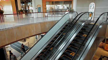 Kuta, Kabupaten Badung, Bali, Endonezya - 6 Kasım 2020: Toplumsal mesafeyi korumak için ayak izi işareti olan bir alışveriş merkezinde siyah merdiven yürüyen merdiven