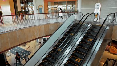 Kuta, Kabupaten Badung, Bali, Endonezya - 6 Kasım 2020: Toplumsal mesafeyi korumak için ayak izi işareti olan bir alışveriş merkezinde siyah merdiven yürüyen merdiven