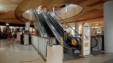 Kuta, Kabupaten Badung, Bali, Endonezya - 6 Kasım 2020: Toplumsal mesafeyi korumak için ayak izi işareti olan bir alışveriş merkezinde siyah merdiven yürüyen merdiven