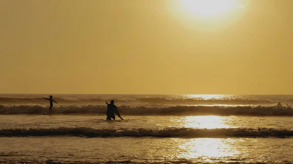 日落时带着桨冲浪的年轻人的轮廓 — 图库照片