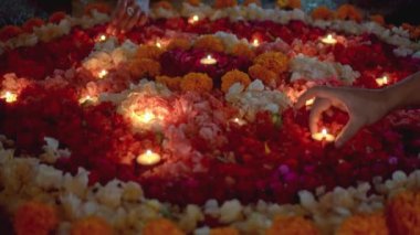 Video, Diwali festivalinde renkli bir çiçek çemberinin içinde mum yaktı.