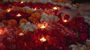 Video, Diwali festivalinde renkli bir çiçek çemberinin içinde mum yaktı.