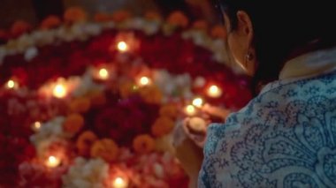 Video, Diwali festivalinde renkli bir çiçek çemberinin içinde mum yaktı.