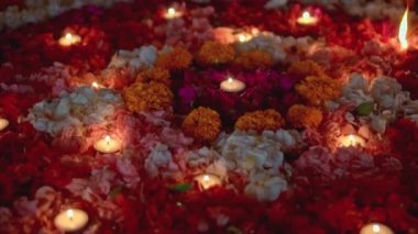 Video, Diwali festivalinde renkli bir çiçek çemberinin içinde mum yaktı.