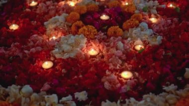 Video, Diwali festivalinde renkli bir çiçek çemberinin içinde mum yaktı.