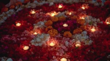 Video, Diwali festivalinde renkli bir çiçek çemberinin içinde mum yaktı.