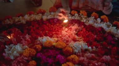 Video, Diwali festivalinde renkli bir çiçek çemberinin içinde mum yaktı.