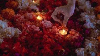 Video, Diwali festivalinde renkli bir çiçek çemberinin içinde mum yaktı.