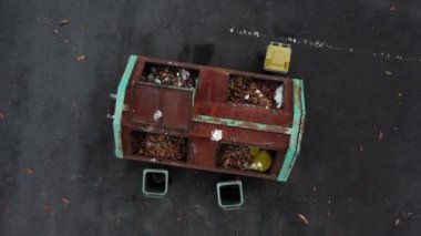 4K video, bir çöp kutusunun uçan dronu hareket bulanıklığı ile yolda duruyor. 