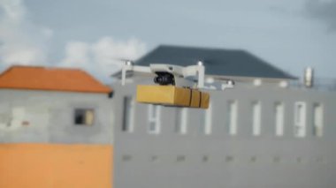 4K video görüntüleri, elinde karton bir paketle gökyüzü teslimatında uçan bir İHA 'nın