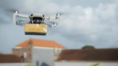 4K video görüntüleri, elinde karton bir paketle gökyüzü teslimatında uçan bir İHA 'nın