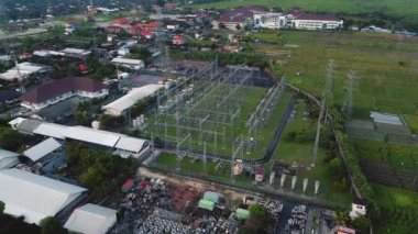 Metal direkler ve elektrik kablolarıyla elektrik iletim istasyonunun İHA 'sından 4K video.