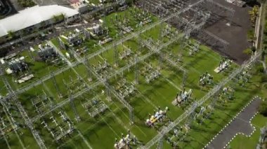 Metal direkler ve elektrik kablolarıyla elektrik iletim istasyonunun İHA 'sından 4K video.