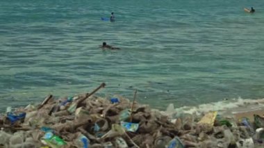 Plaj kirliliği. Plastik çöp ve deniz sahilindeki diğer çöplerin 4K videosu. Ekolojik kavram