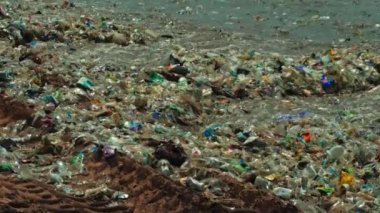 Plaj kirliliği. Plastik çöp ve deniz sahilindeki diğer çöplerin 4K videosu. Ekolojik kavram