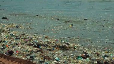 Plaj kirliliği. Plastik çöp ve deniz sahilindeki diğer çöplerin 4K videosu. Ekolojik kavram
