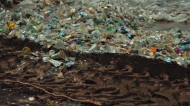 Plaj kirliliği. Plastik çöp ve deniz sahilindeki diğer çöplerin 4K videosu. Ekolojik kavram