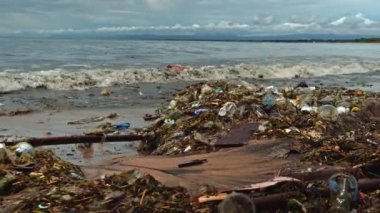Plaj kirliliği. Plastik çöp ve deniz sahilindeki diğer çöplerin 4K videosu. Ekolojik kavram