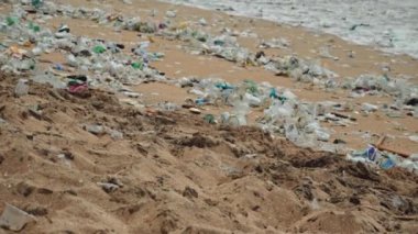 Plaj kirliliği. Plastik çöp ve deniz sahilindeki diğer çöplerin 4K videosu. Ekolojik kavram