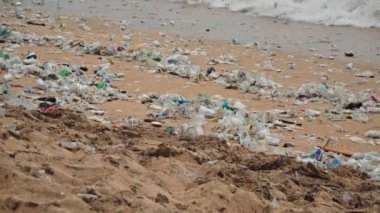 Plaj kirliliği. Plastik çöp ve deniz sahilindeki diğer çöplerin 4K videosu. Ekolojik kavram