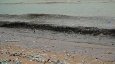 Plaj kirliliği. Plastik çöp ve deniz sahilindeki diğer çöplerin 4K videosu. Ekolojik kavram
