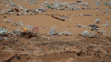 Plaj kirliliği. Plastik çöp ve deniz sahilindeki diğer çöplerin 4K videosu. Ekolojik kavram