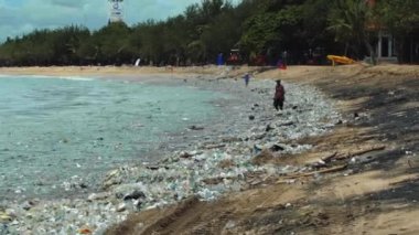 Plaj kirliliği. Plastik çöp ve deniz sahilindeki diğer çöplerin 4K videosu. Ekolojik kavram