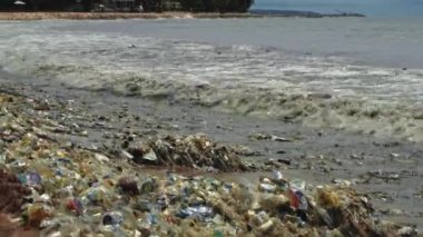 Plaj kirliliği. Plastik çöp ve deniz sahilindeki diğer çöplerin 4K videosu. Ekolojik kavram