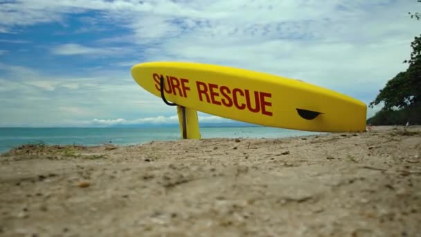ビーチでの黄色のサーフボード バリ島のビーチでの赤いテキストサーフィン救助緊急事態 — ストック動画
