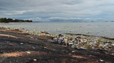 Plaj kirliliği. Plastik çöp ve deniz sahilindeki diğer çöplerin 4K videosu. Ekolojik kavram