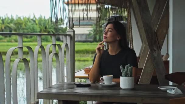Молодая Европейская Девушка Сидит Столом Общественном Месте Чашкой Кофе Рядом — стоковое видео