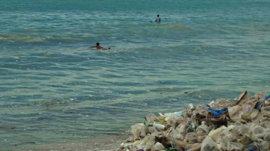 Plaj kirliliği. Plastik çöp ve deniz sahilindeki diğer çöplerin 4K videosu. Ekolojik kavram