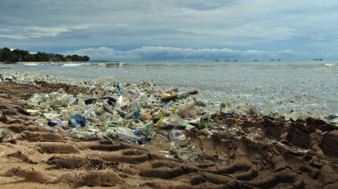 Plaj kirliliği. Plastik çöp ve deniz sahilindeki diğer çöplerin 4K videosu. Ekolojik kavram