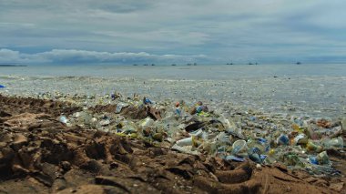 Plaj kirliliği. Plastik çöp ve deniz sahilindeki diğer çöplerin 4K videosu. Ekolojik kavram