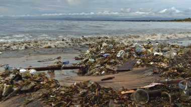 Plaj kirliliği. Plastik çöp ve deniz sahilindeki diğer çöplerin 4K videosu. Ekolojik kavram