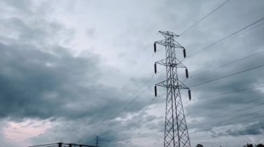 Gün batımında yeşil pirinç tarlasında yeni inşa edilmiş bir elektrik iletim kulesinin hava aracı görüntüsü.