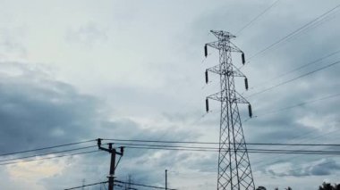 Gün batımında yeşil pirinç tarlasında yeni inşa edilmiş bir elektrik iletim kulesinin hava aracı görüntüsü.