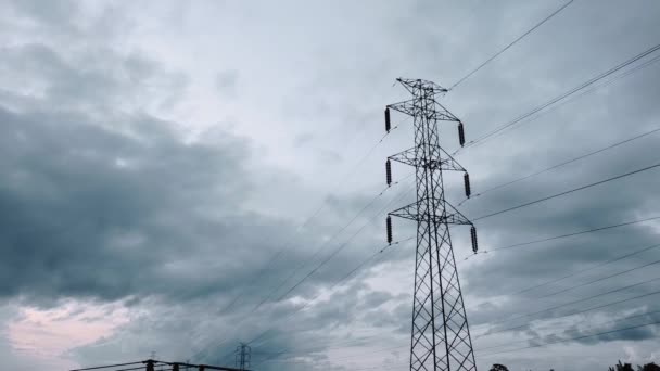 夕日の緑の田に新設された送電塔の空中ドローンビュー — ストック動画