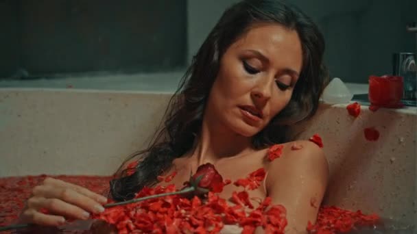 กสาวชาวย โรป ผมยาว ผมส เนท นอนอย ในห องน ดอกไม แดงบนข — วีดีโอสต็อก