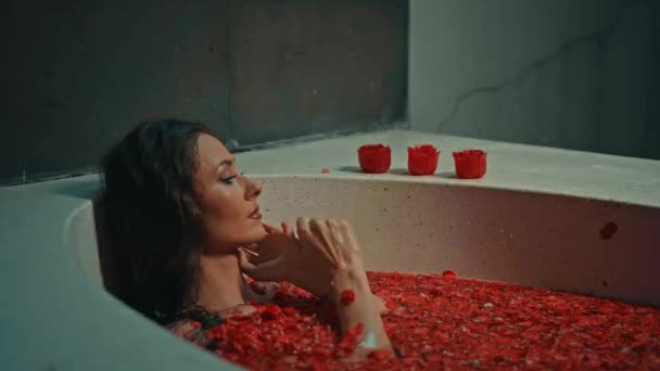 กสาวชาวย โรปผมยาวส าตาลนอนอย ในห องน ดอกไม แดงบนข นตอนสปาด วยสบ ในร — วีดีโอสต็อก