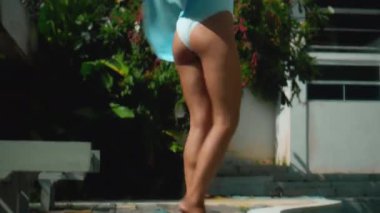 Genç Avrupalı esmer kız arka bahçesinde yeşil bahçeli bir havluyu siler.