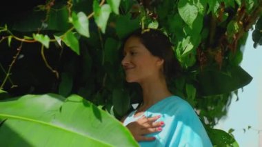 Genç Avrupalı esmer kız arka bahçesinde yeşil bahçeli bir havluyu siler.