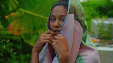 Genç Avrupalı esmer kız arka bahçesinde yeşil bahçeli bir havluyu siler.