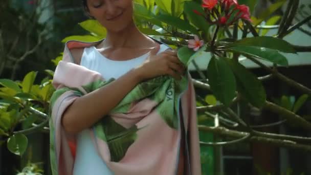 若いヨーロッパのブルネットの女の子は背景に緑の庭で裏庭にタオルを拭く — ストック動画