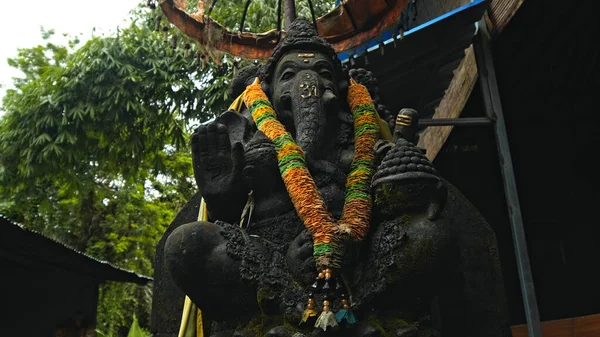 Stary Kamienny Posąg Ganeshy Pokryty Mchem Wieńcem Żółtych Kwiatów Szyi — Zdjęcie stockowe