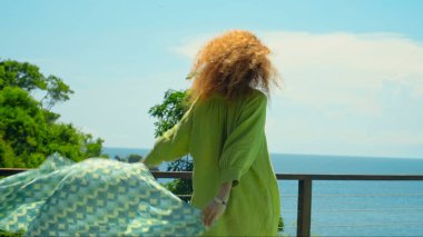 Kızıl saçlı genç bir kız bahçesinde çimlerin üzerinde yeşil bahçeli güzel yeşil elbiseli.